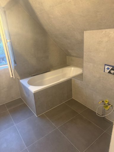 Badezimmer mit Schrägdach, grauen matten Fliesen und 120x60 Verkleidung